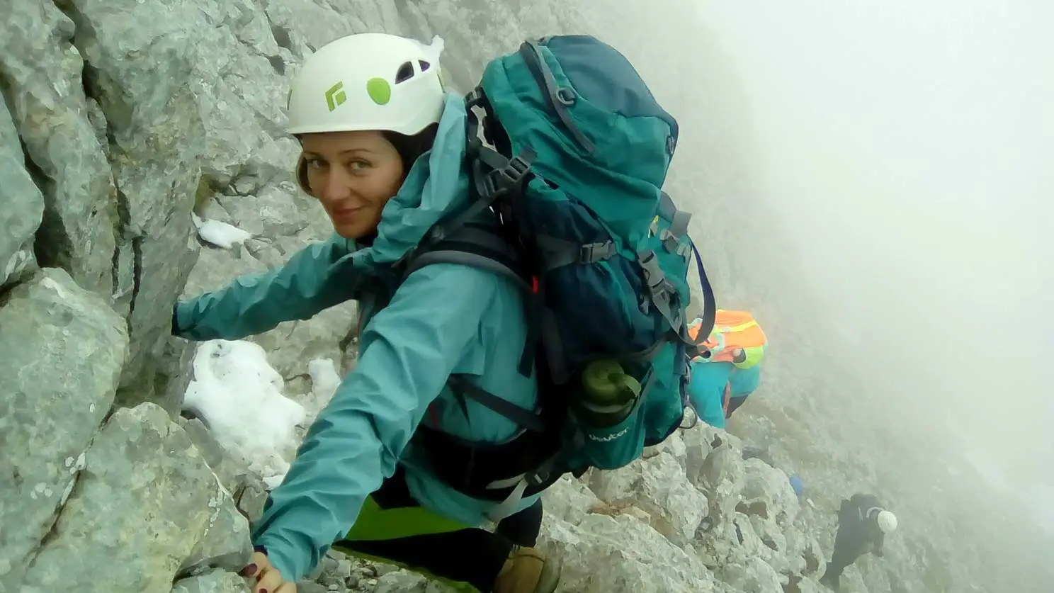 Climber with a helmet on a rock face