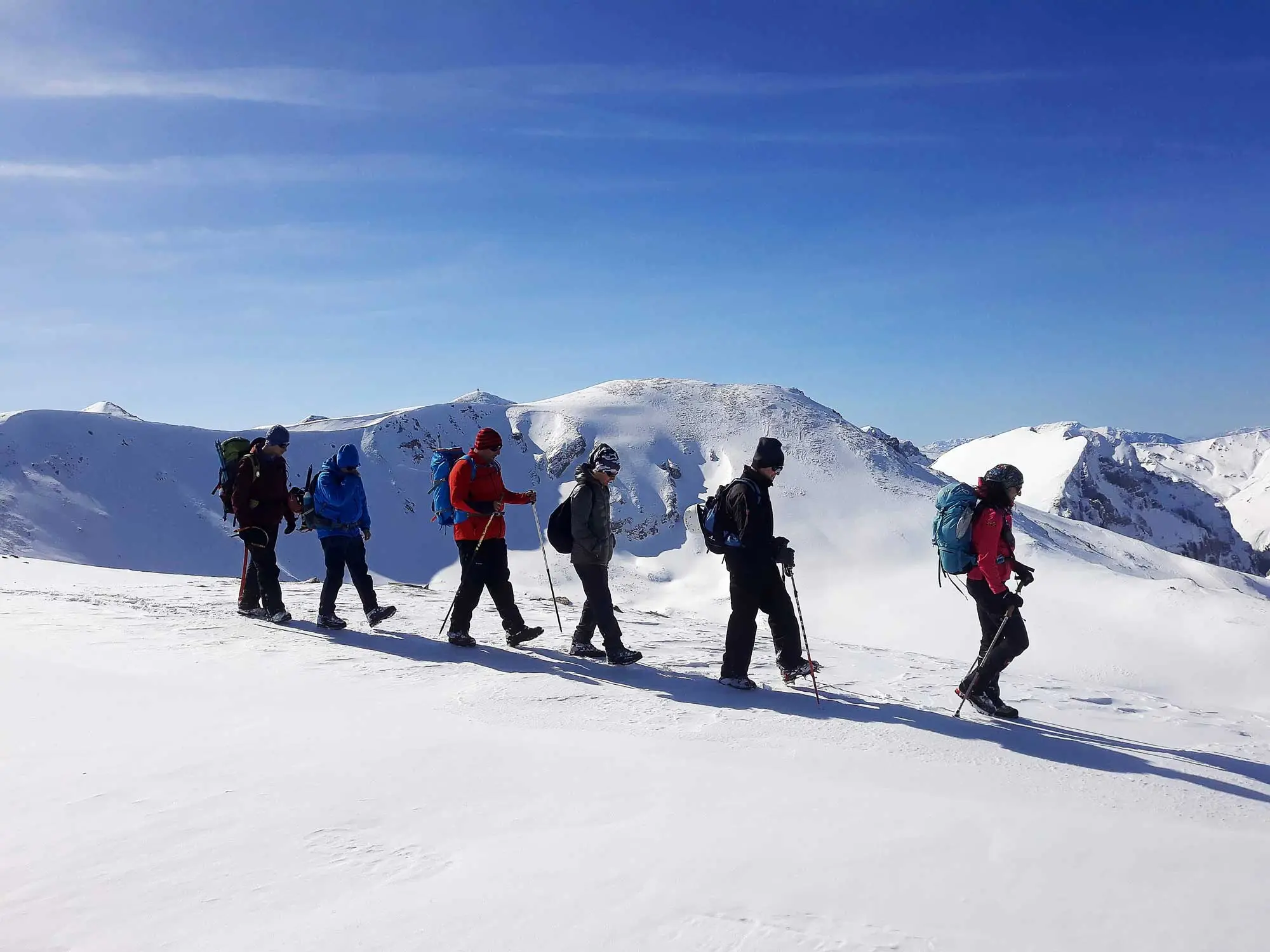 Hikers on a snowy mountain ridge