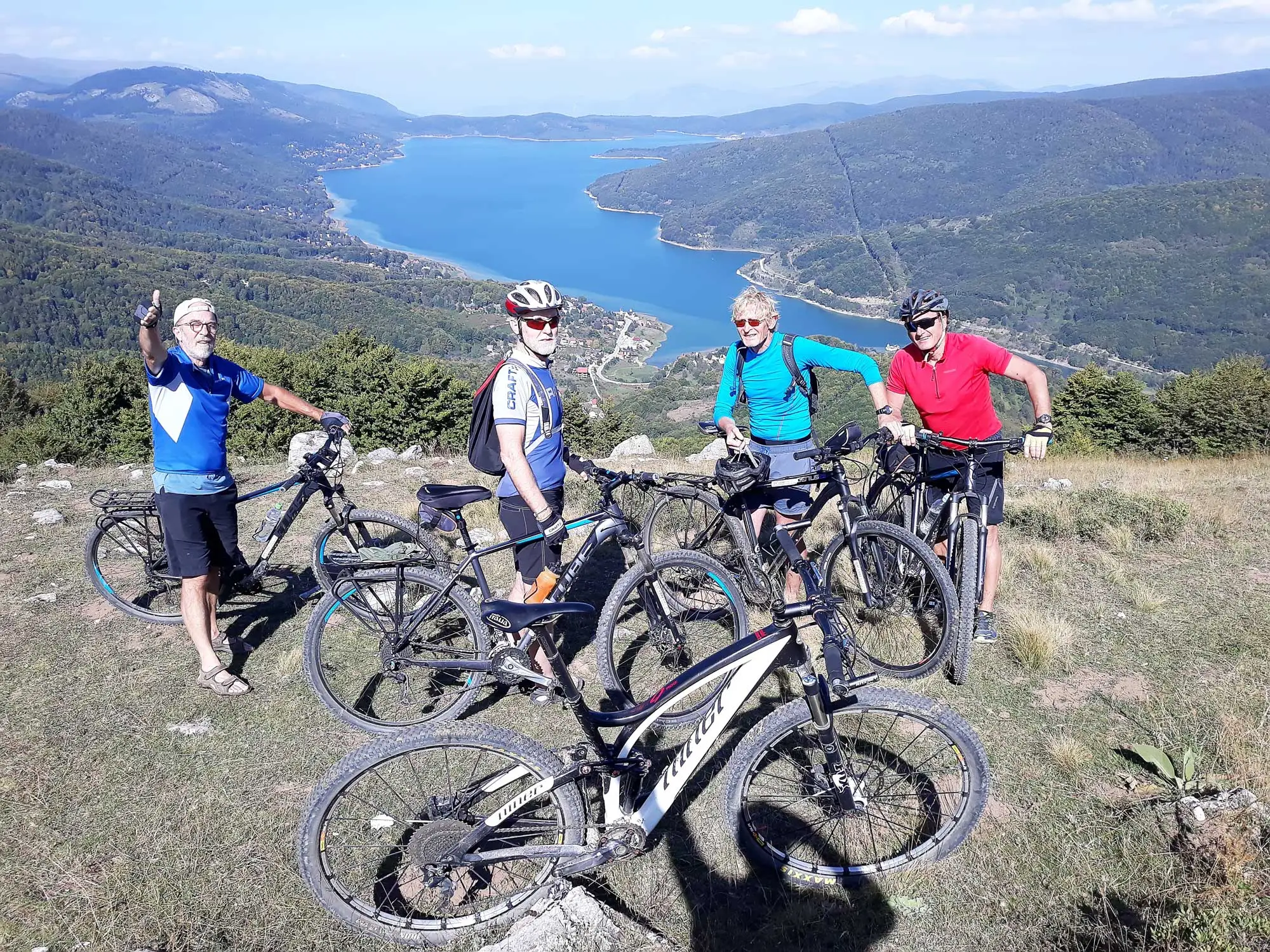 Riders with their bikes on a ridge above Lake Mavrovo