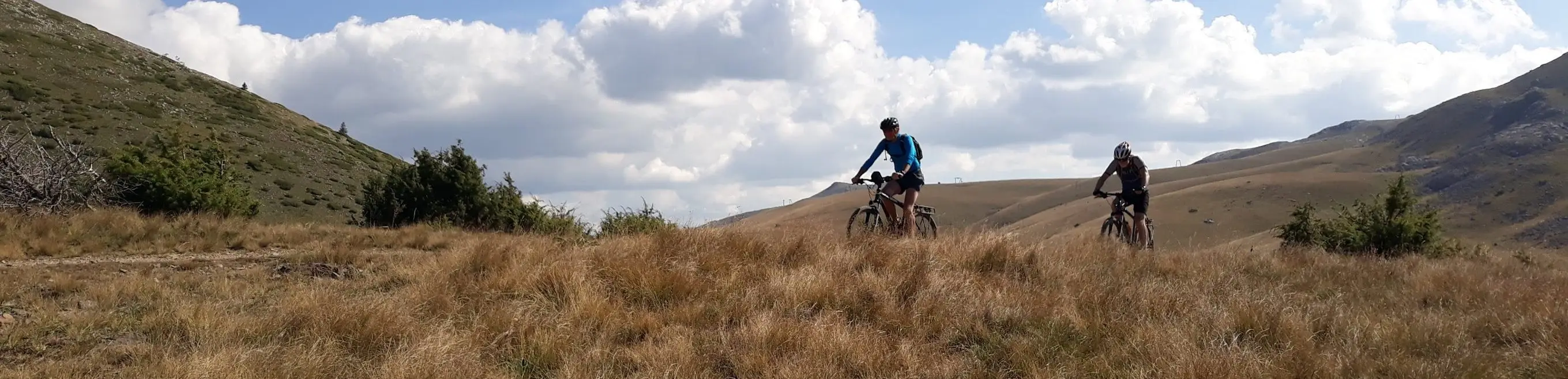 Mountain biker on a grassy ridge trail