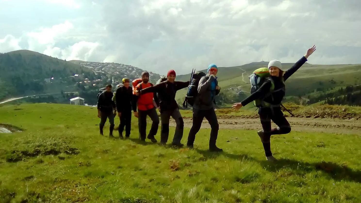 Team jumping for a photo on a mountain meadow