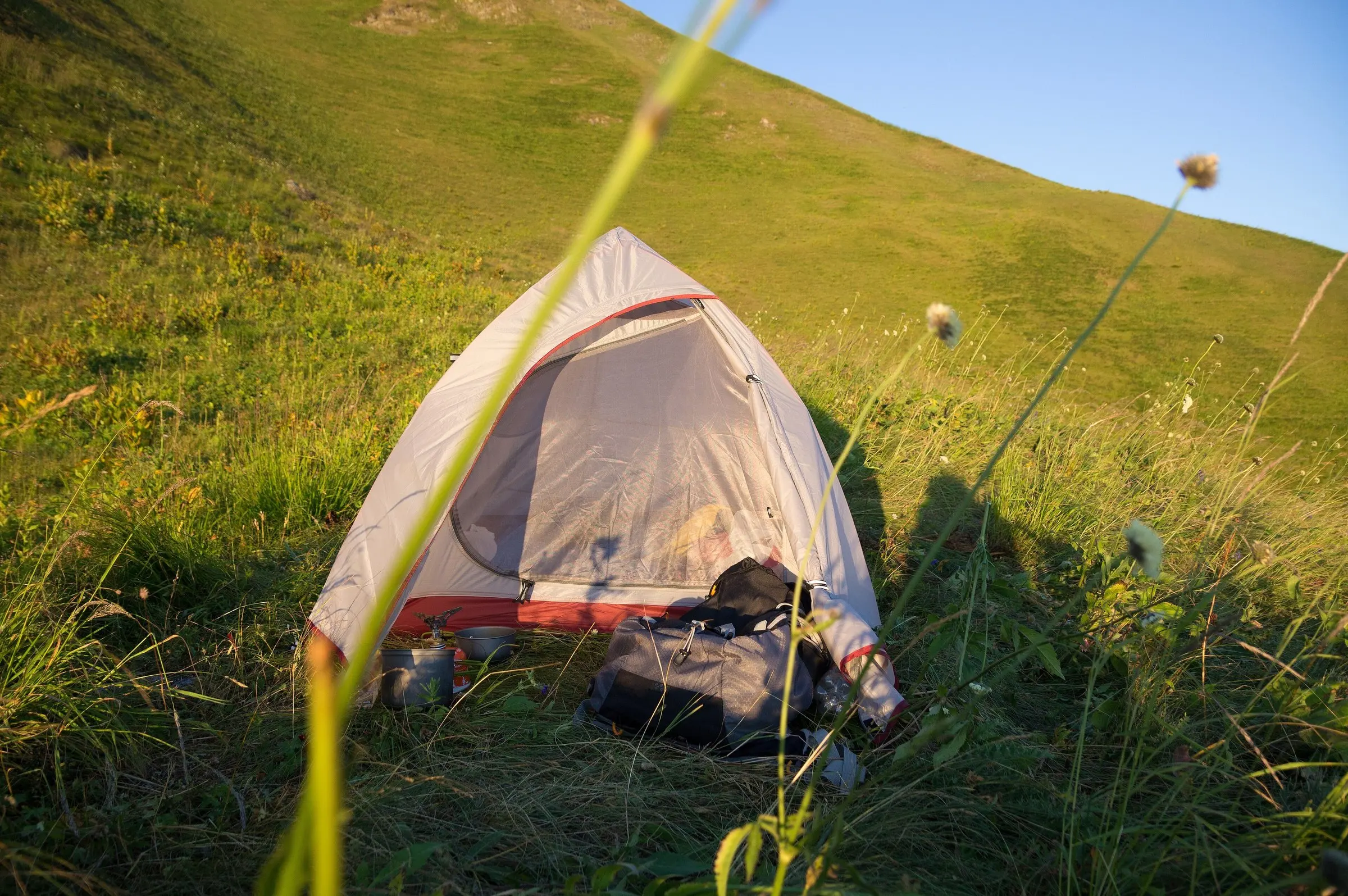 Tent on a grassy mountain slope
