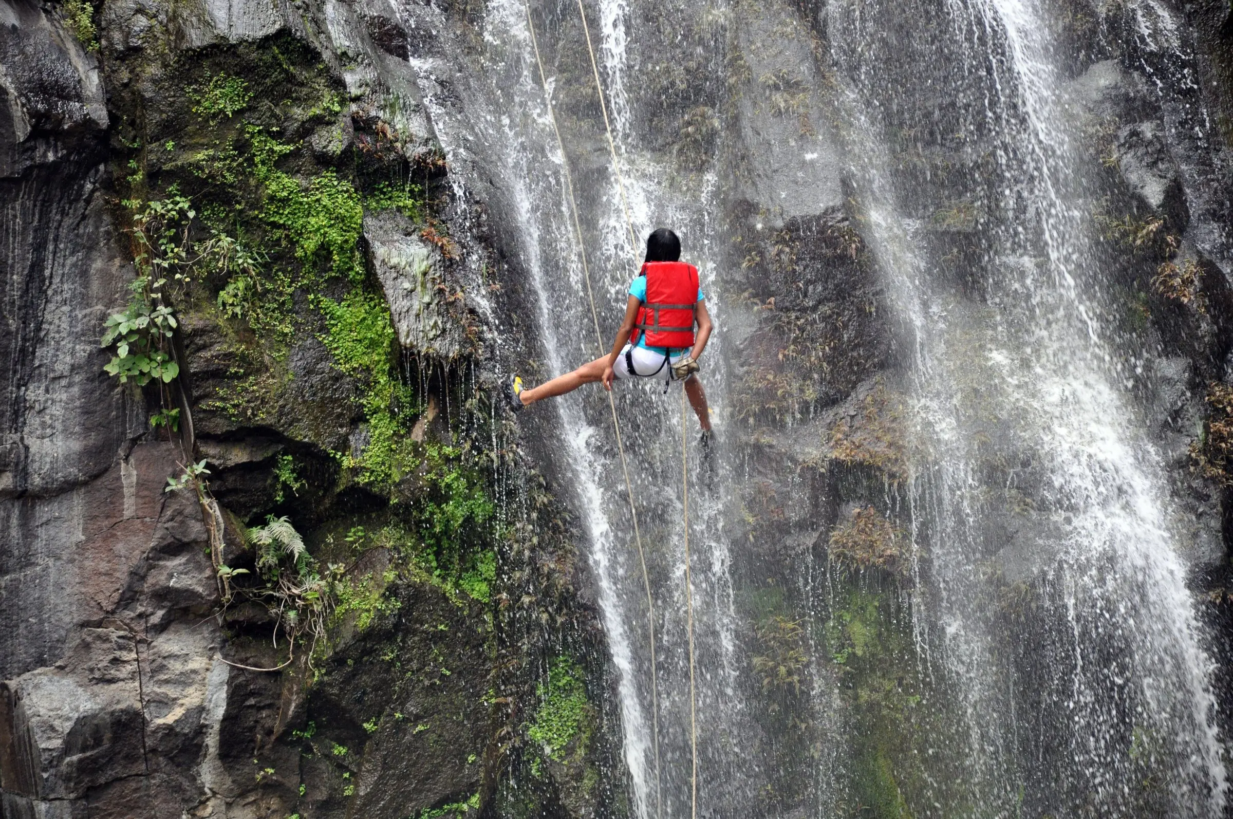 Abseiling down a waterfall while canyoning