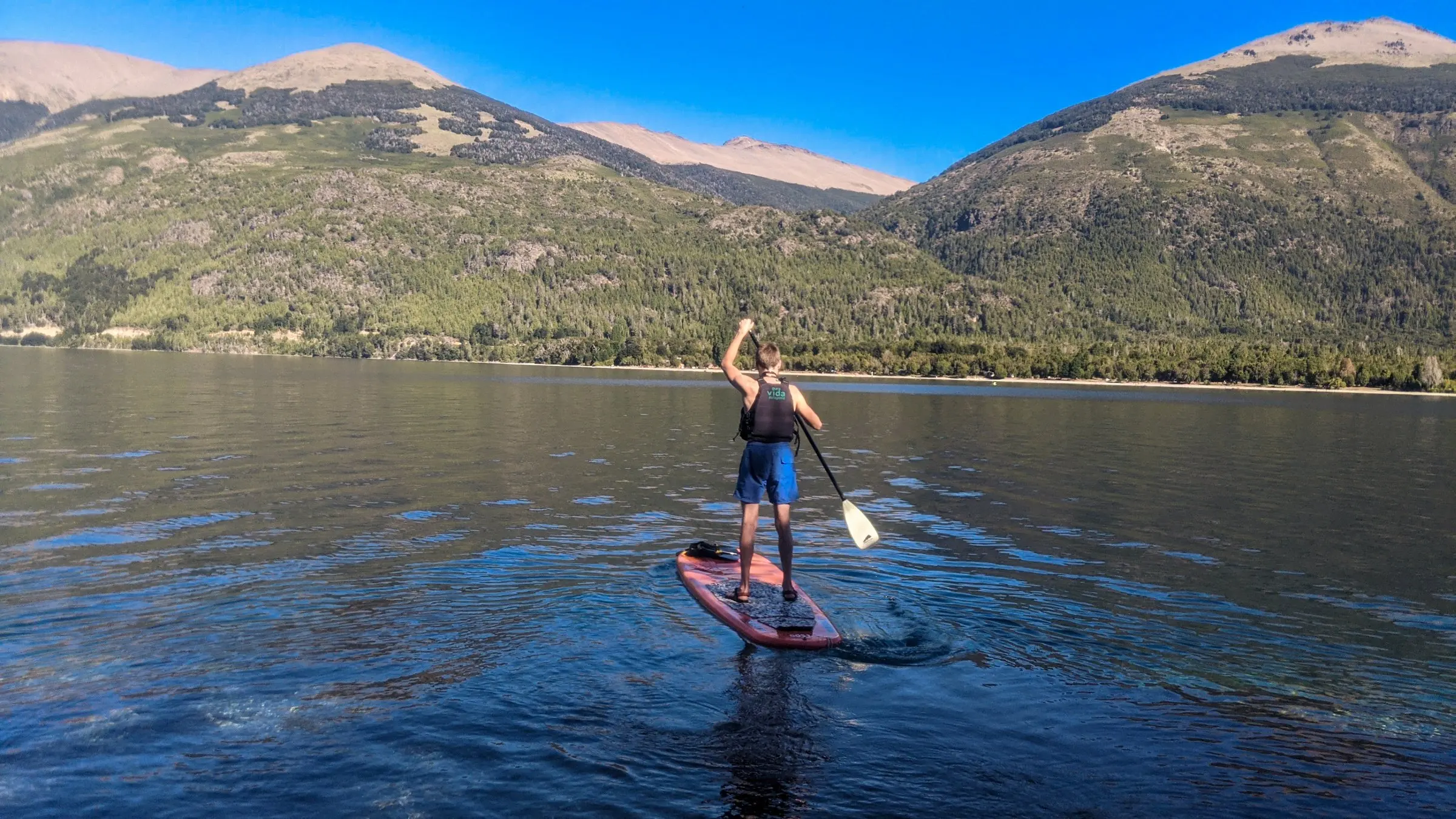 Stand-up paddleboarder on a mountain lake