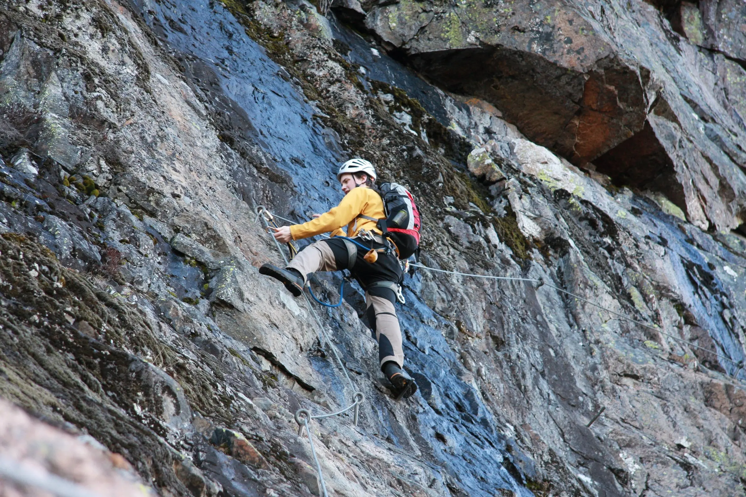 Climber on a via ferrata, clipped to the steel cable