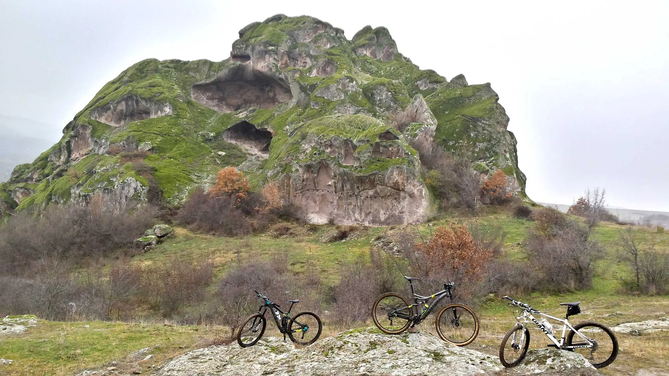 Mountain bikes parked below a rock outcrop